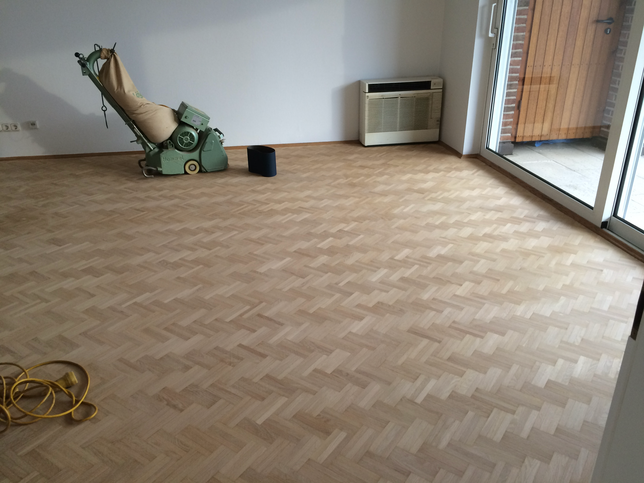 Parkettschleifmaschine auf frisch geschliffenem Mosaikparkett